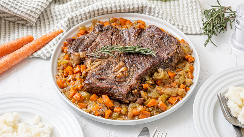 Pot roast over roasted vegetables, topped with thyme