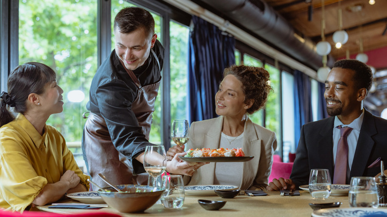 Waiter serving food to a table