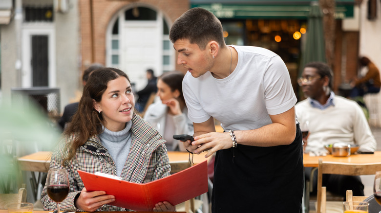 Woman ordering from a waiter at a restaurant