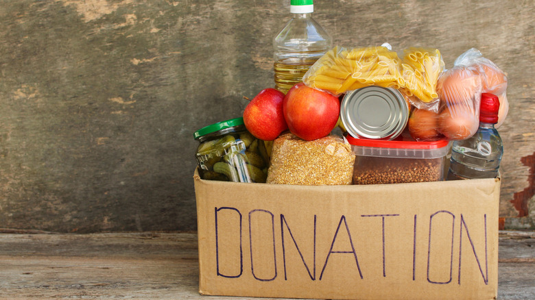 Cardboard box full of food with a donation label written on the front