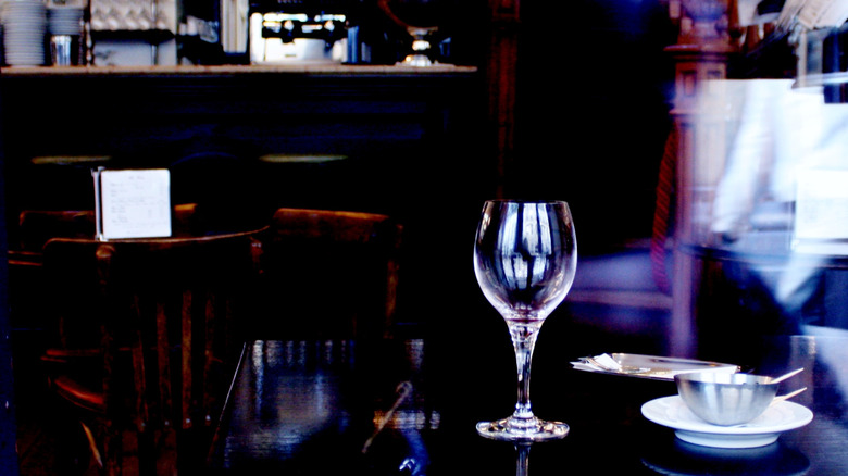 Artistically blurry photo of an empty wineglass on a Paris bistro table