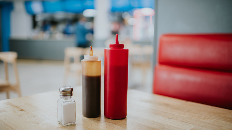 A diner booth with condiments on the table