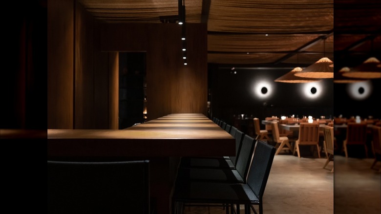 The interior of a darkly lit restaurant with a long counter