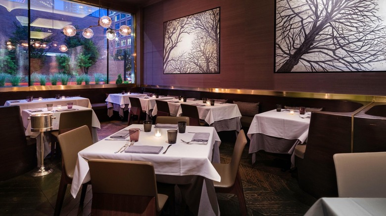 An upscale restaurant with white tablecloths and artwork