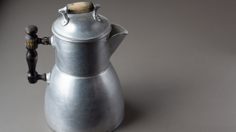A vintage percolator on a grey background