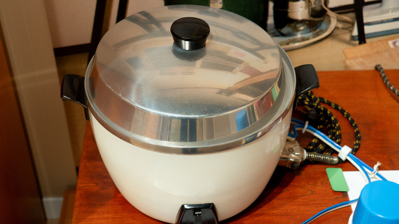 A vintage electric rice cooker sitting on a counter