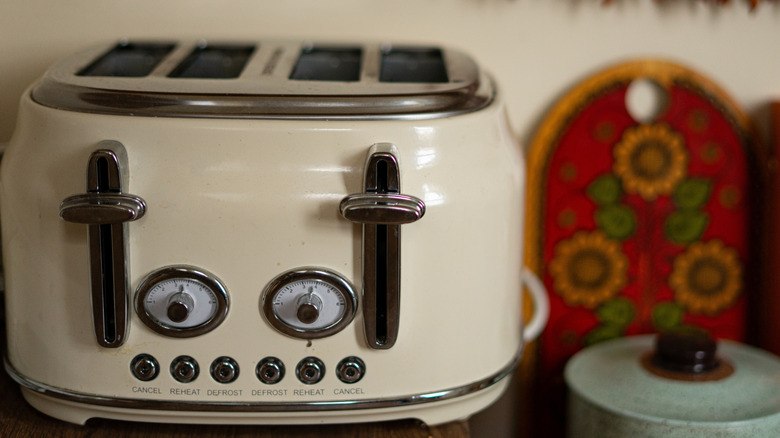 A vintage cream colored toaster on a kitchen counter