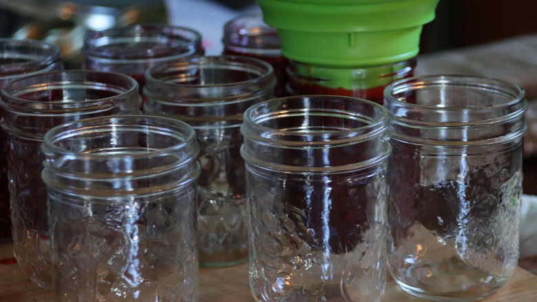 mason jars being filled with cooled jam