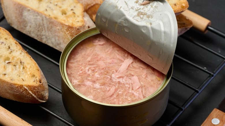open tuna can next to slices of bread