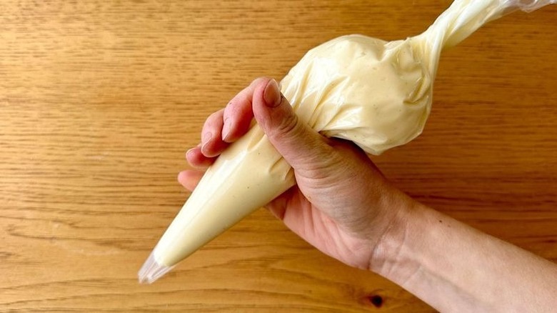 Hand holding frosting in piping bag