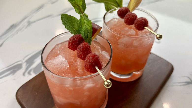 Garnished peach and raspberry bourbon smashes