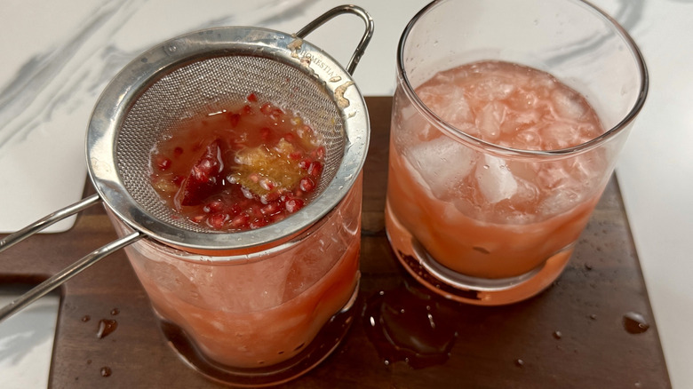 Straining drink into glasses