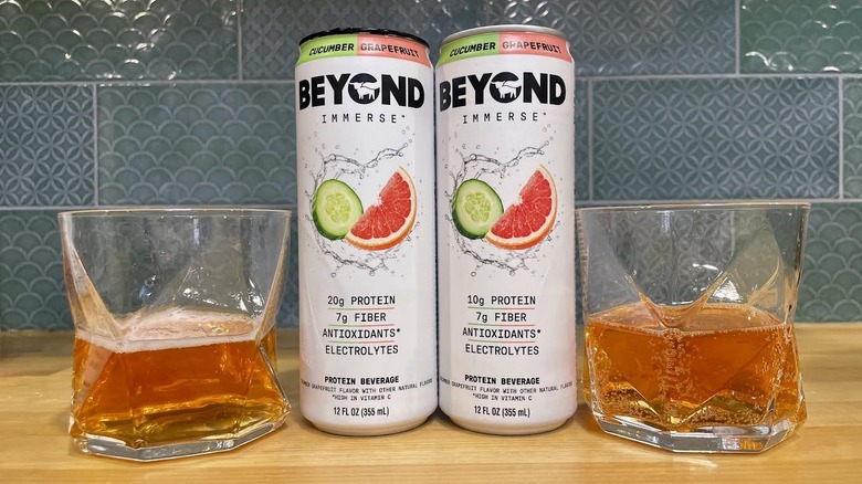 Cans and glasses of Beyond Immerse Cucumber Grapefruit on countertop