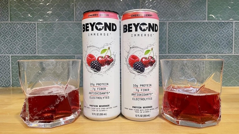 Cans and glasses of Beyond Immerse Cherry Berry on countertop