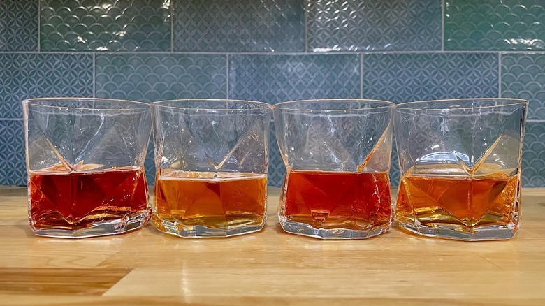 Four glasses of Beyond Immerse protein drinks on a wooden countertop