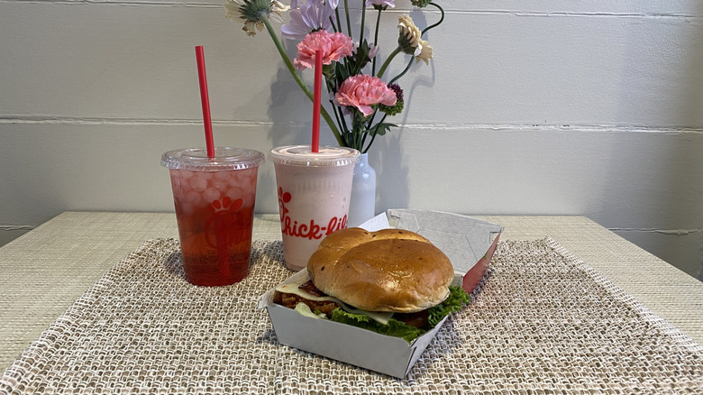 Two Chick-fil-A drinks and a chicken sandwich on a table