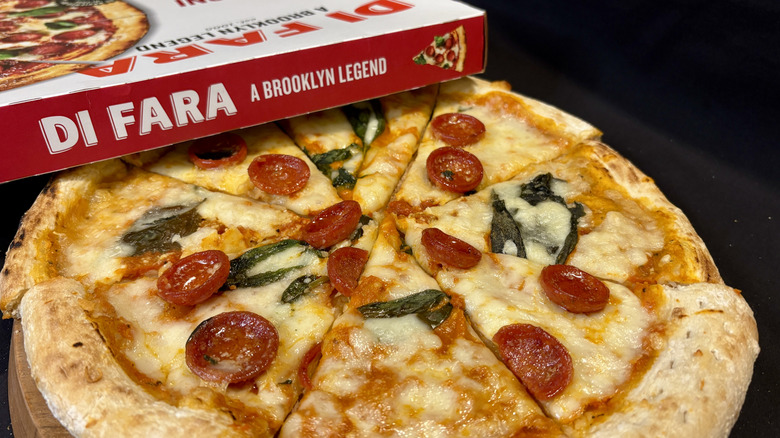 various pizza slices together on a board with pizza box on top