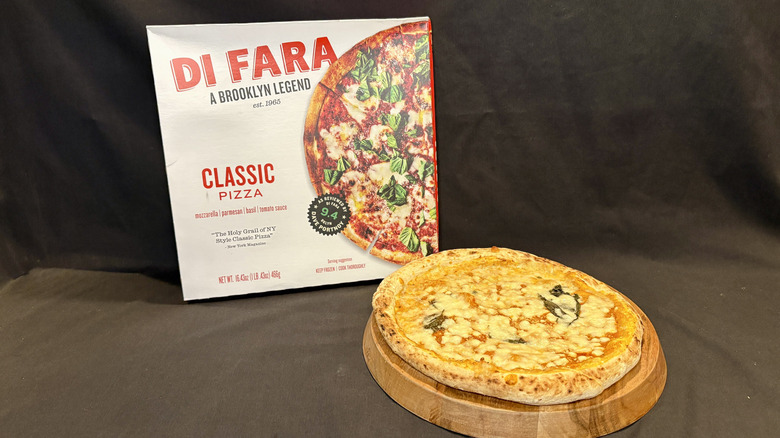 pizza on wooden board in front of Di Fara pizza box