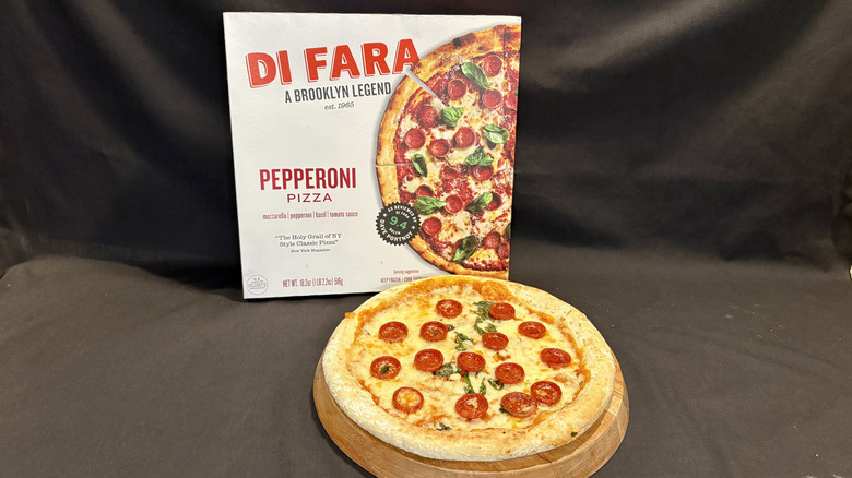 pizza on wooden board in front of Di Fara pizza box