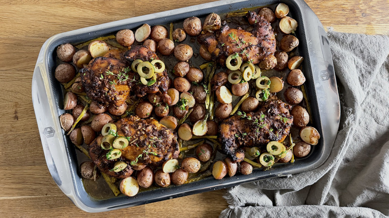 A chicken sheet pan dinner next to a brown towel
