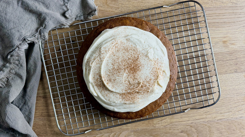Pumpkin cake with cream cheese frosting on a cooling rack