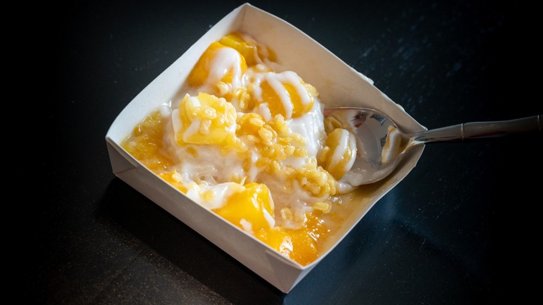 A tray of Trader Joe's Mango Sticky Rice with a silver spoon