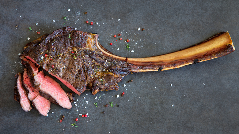 Tomahawk steak sprinkled with peppercorns