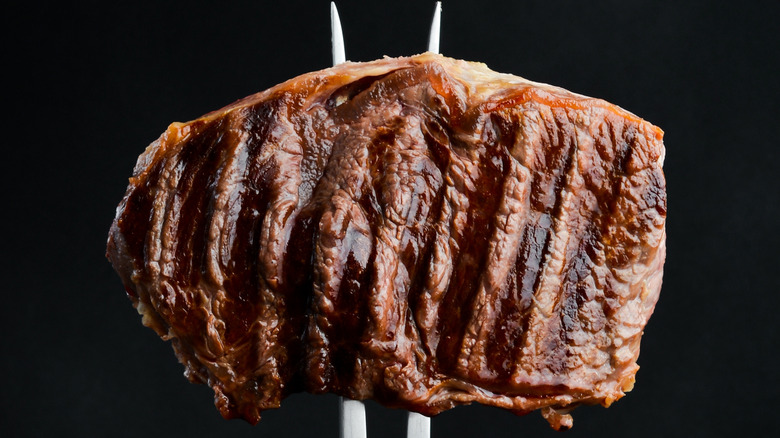 A ribeye shown speared on a fork