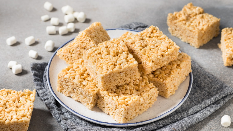 a plate of rice krispies treats with marshmallows scattered around it