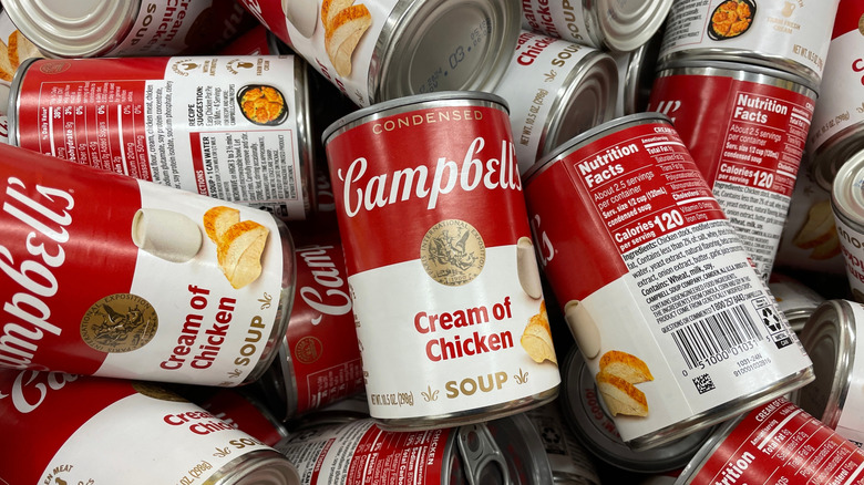 A pile of Campbell's Cream of Chicken Condensed Soup stacked on top of each other