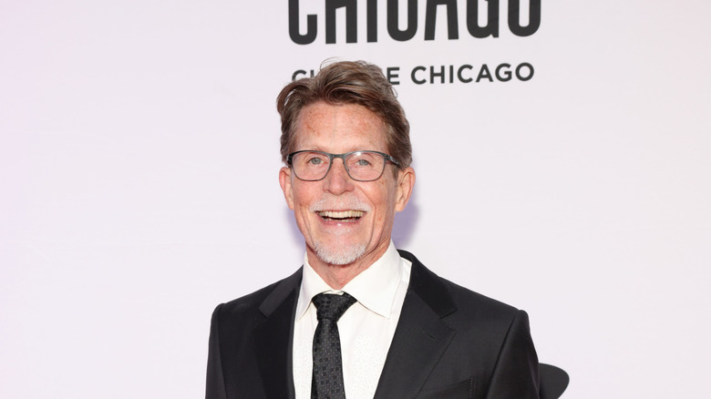 Rick Bayless smiling in a suit and tie at the 2024 James Beard Awards