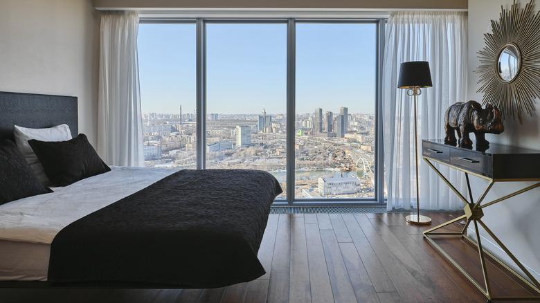 A nice hotel room with floor-to-ceiling windows and a city view
