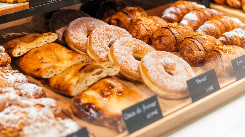 Pastries and donuts displayed on a bakery shelf