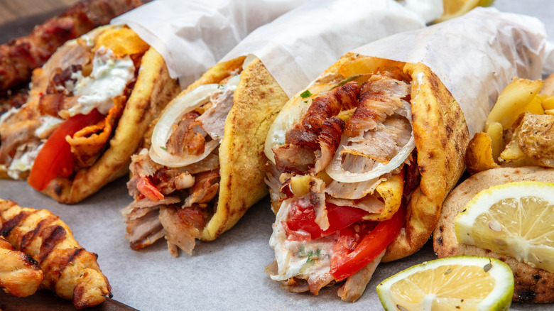 Gyros pita wraps filled with shaved meat, onions, tomatoes, and sauce