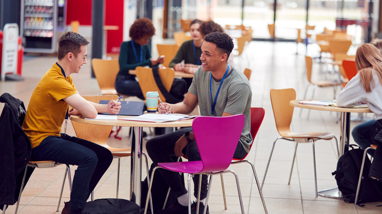 Students sitting at cafeteria tables at a university.