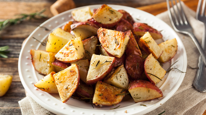 roasted herb potatoes sit on a white plate