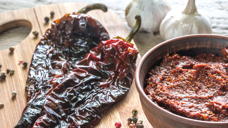 bowl of mexican adobo next to dried chiles