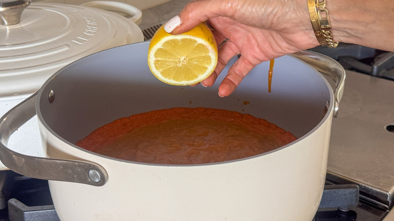 hand adding lemon to pot