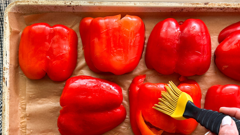 hand brushing pepper with oil