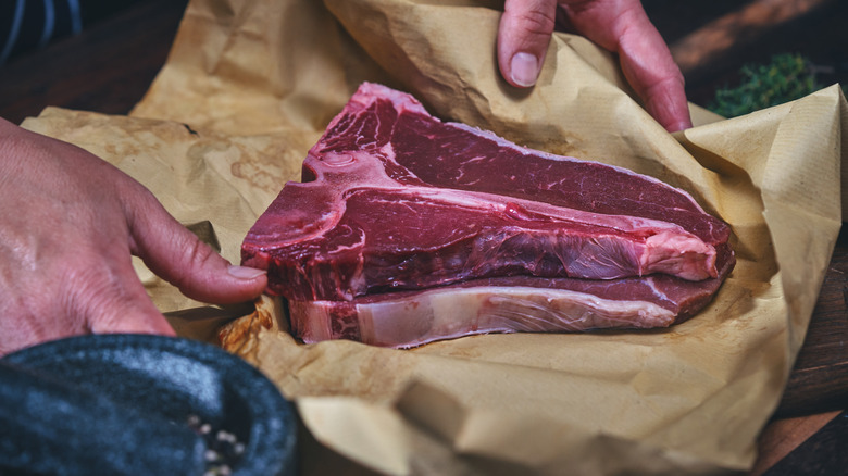 Raw T-bone steak on butcher paper