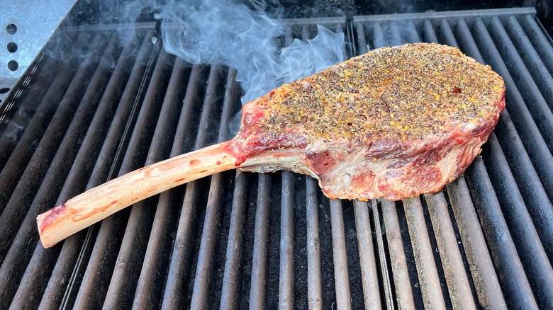 Searing tomahawk steak on a grill