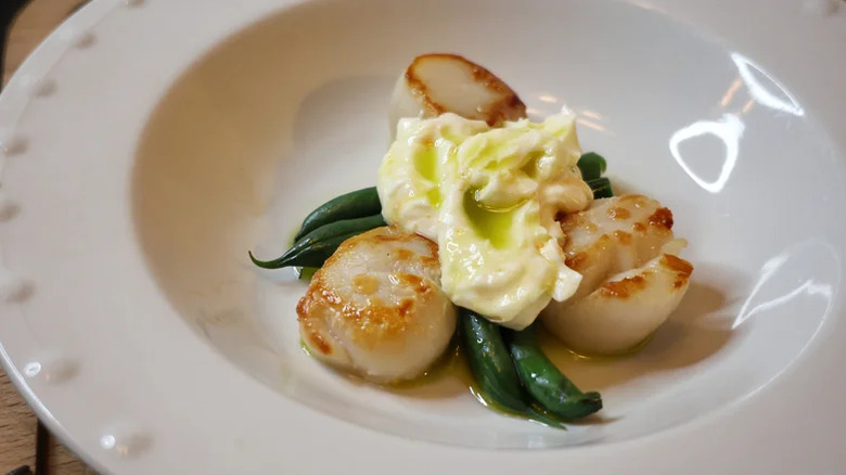 Plate of scallops with whipped topping.