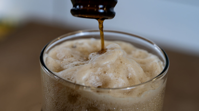 Root beer being poured in a glass