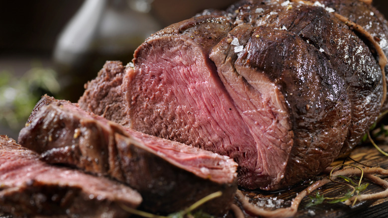Cooked sirloin steak with pink center on a cutting board