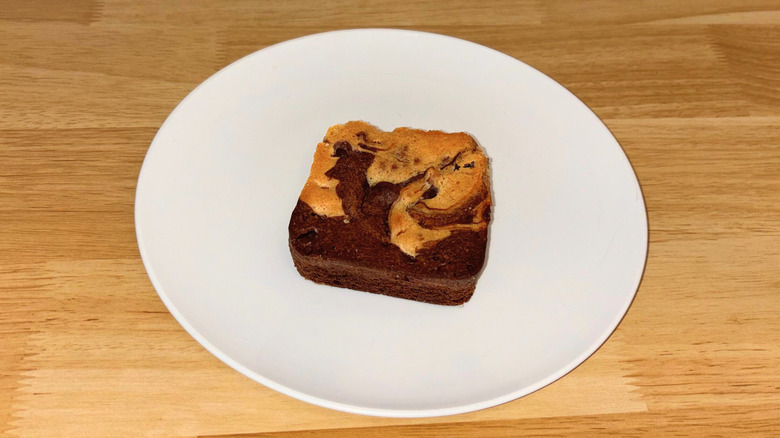 A cookie dough brownie on a white plate.