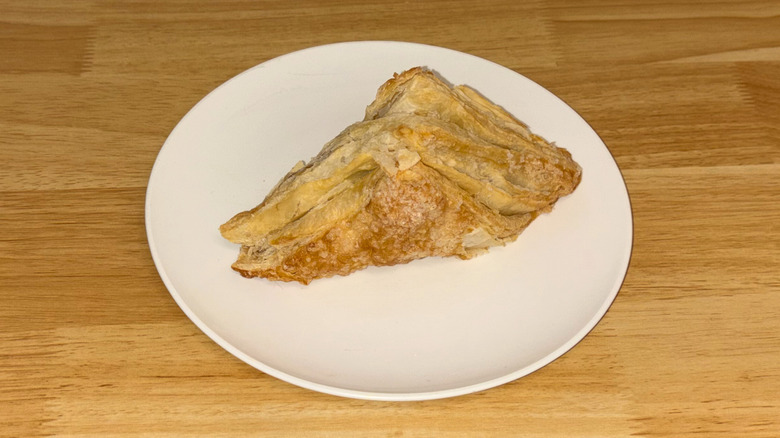 A flaky apple turnover on a white plate.
