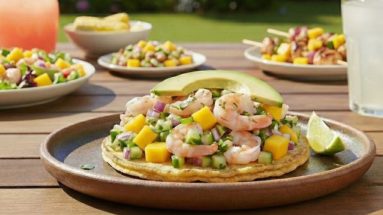 Mango shrimp ceviche in a plate with lemon wedge on the side
