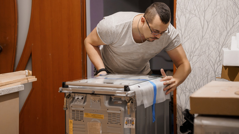 Man installing a new dishwasher in a kitchen