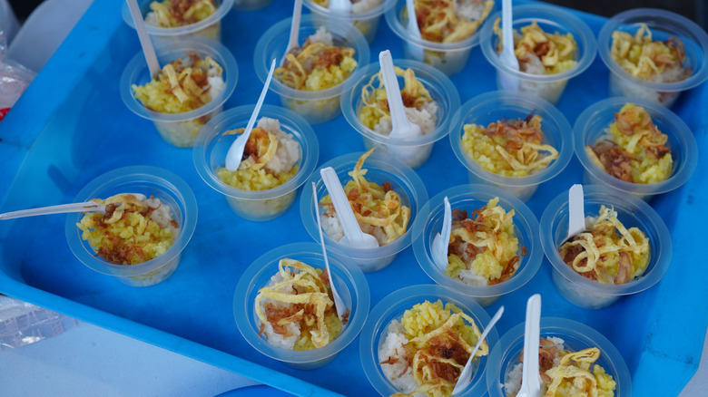 A blue tray of free sample cups containing a savory dish