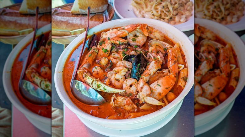 Heaping bowl of Cioppino from Sotto Mare on table at restaurant.